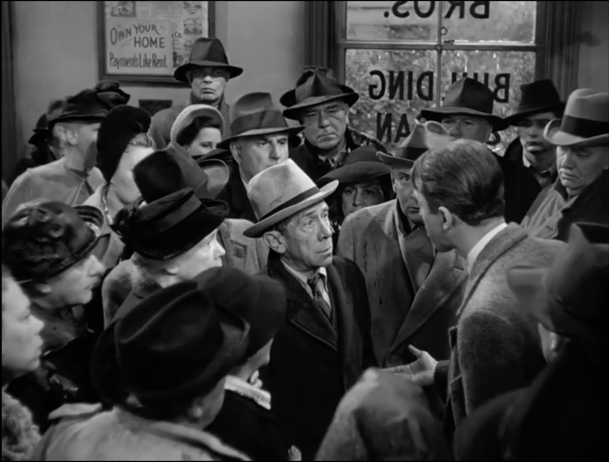 A screencap from It's a Wonderful Life's bank run scene, centered on poor Ed.